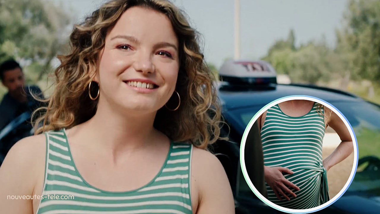 Kelly enceinte souriante devant un taxi, robe à rayures vertes, ventre arrondi bien visible dans Ici tout commence