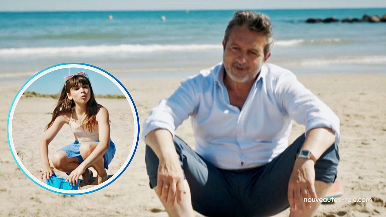 Victor assis sur le sable, souriant face à Nina qui joue avec un seau sur la plage dans Demain nous appartient, épisode 1983